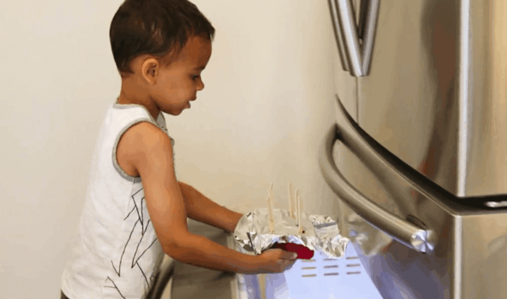 孩子将冰盘放入冰箱。