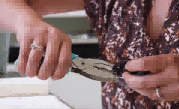 家长在收缩包装塑料月亮上使用打孔器。